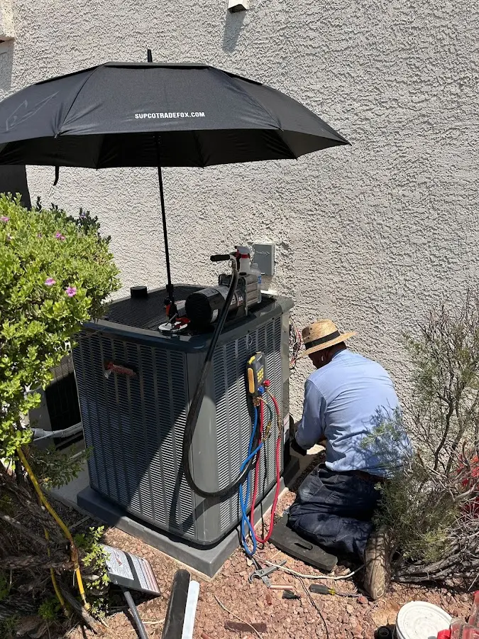 HVAC technician performing outdoor AC maintenance in Topeka